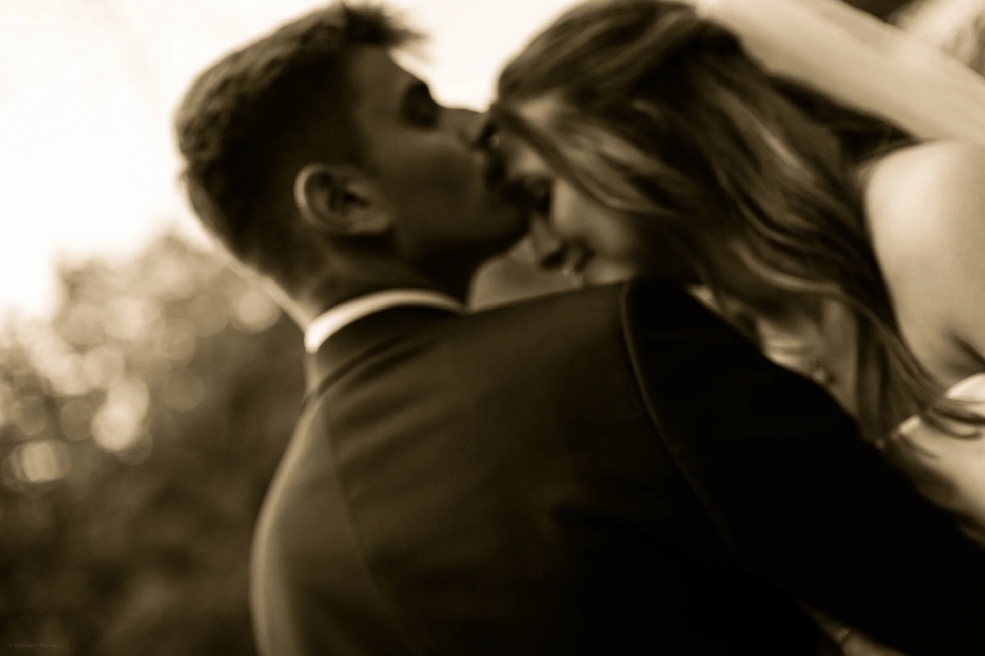 Un baiser des mariés, photographié en noir et blanc.