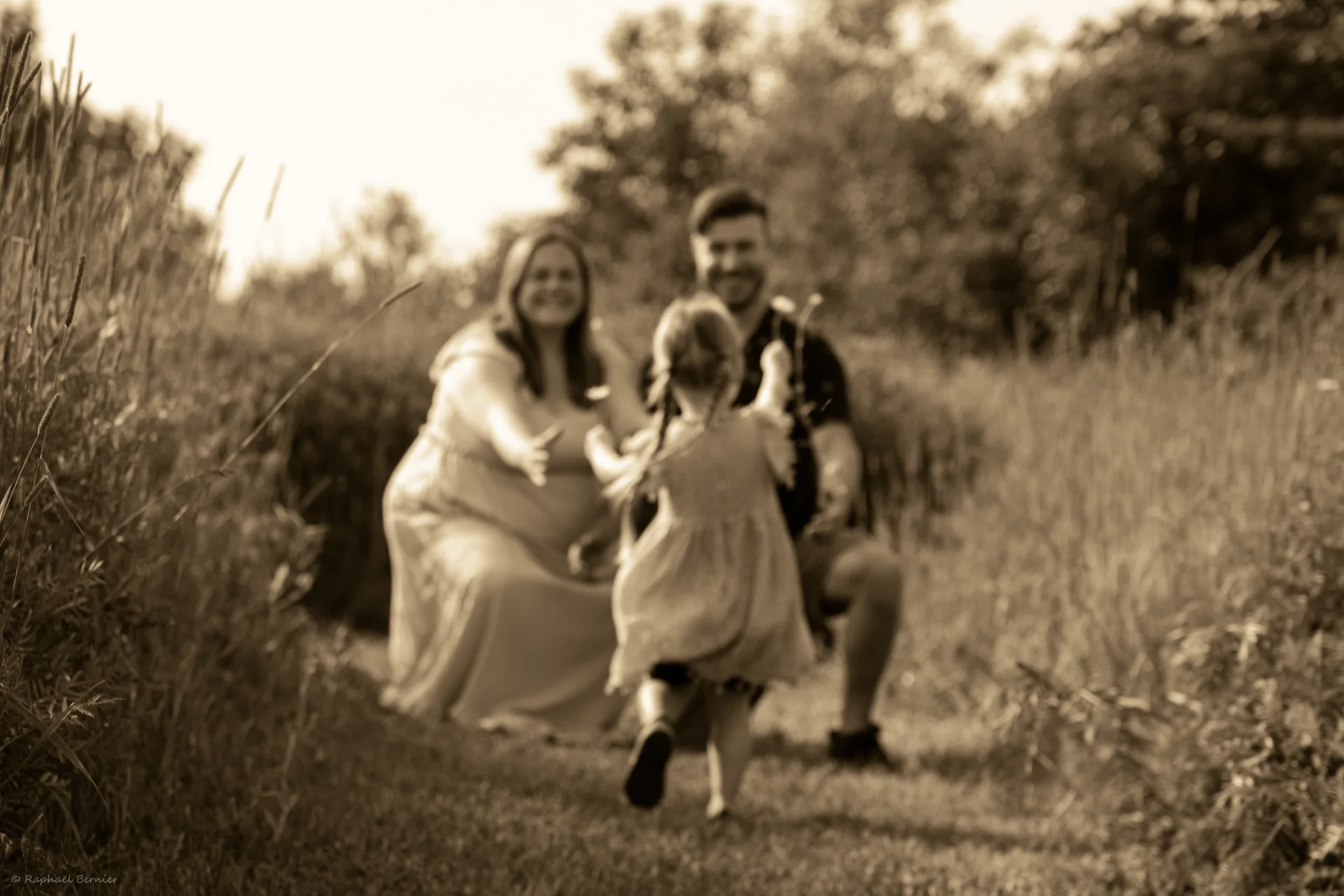 A family walks together through a field in black and white.